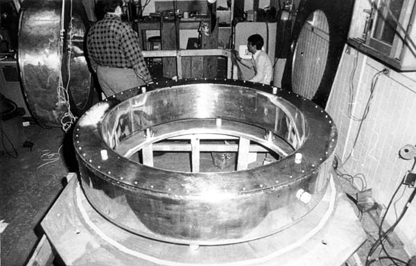 Michael Goldsmith and Nean Hu with the liquid helium cryogen chamber that housed the NbTi superconductiong magnet coil.